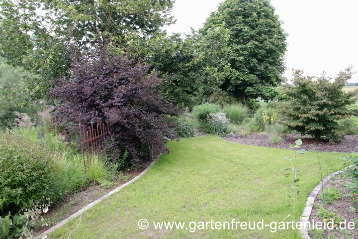 Eine kleine Grasfl&auml;che teilt verschiedene Gartenr&auml;ume